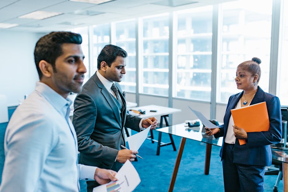 Business professionals discussing documents in a modern office environment.